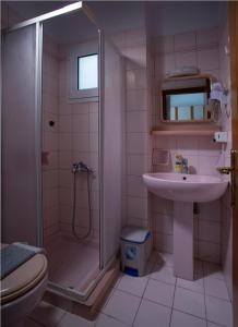 a bathroom with a shower and a sink and a toilet at Spiros Studios in Parga