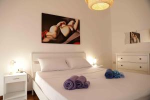 a bedroom with a white bed with towels on it at casa Ada in SantʼAntìoco