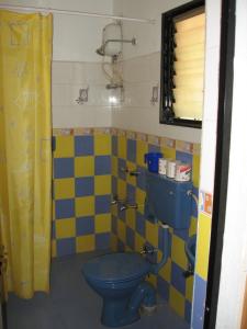 y baño con aseo azul y amarillo y azul. en Bethany Inn, en Vagator
