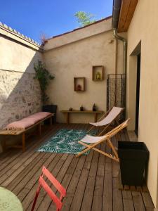 un patio con 2 sillas, una mesa y una alfombra en LOFT COCON EN PLEIN CENTRE DE SETE en Sète