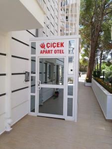 een bord dat een chequekantoor achter een deur leest bij ÇİÇEK APART OTEL in Didim