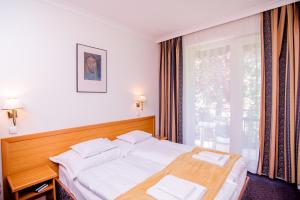 ヘーヴィーズにあるNymphea Villaのベッドルーム1室(白いシーツ付きのベッド1台、窓付)
