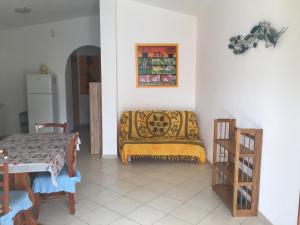 a living room with a table and a yellow blanket at Casa Mare in Solanas