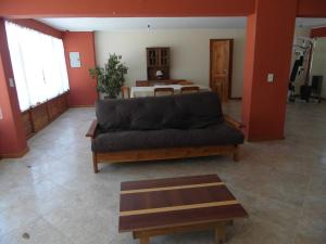 a living room with a black couch and a table at La Cabaña de Juan in Villa Traful