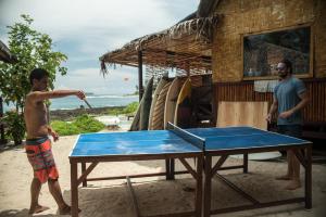 dos hombres jugando ping pong en una mesa de ping pong en Simeulue Surflodges, en Lasikin