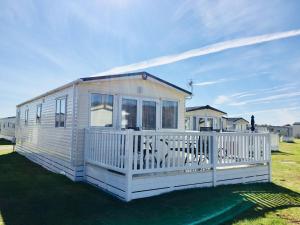 a small white house with a white fence at 87 Lighthouse View Lodge in Lossiemouth