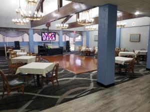 a dining room with tables and chairs and a television at Florence Express Inn in Florence