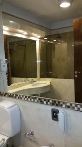 a bathroom with a toilet and a sink and a mirror at Hotel Viñas del Sol in San Juan