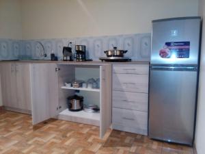 クスコにあるBLUEIBY HOMEのキッチン(ステンレス製の冷蔵庫、白いキャビネット付)