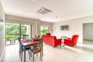 a living room with red furniture and a table at Jaco Bay 2102 in Jacó