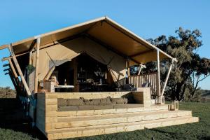 a large tent with a couch in a field at Rosewood Farmstay in Binda