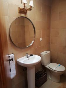 a bathroom with a sink and a toilet and a mirror at Abrigo Montesinho in Montezinho