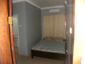 ein kleines Schlafzimmer mit einem Bett und einem Fenster in der Unterkunft Biso Inn in Alimosho