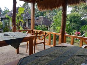 a patio with a table and chairs on a deck at Rumah Sidemen in Sidemen