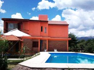 a house with a swimming pool in front of it at Complejo Los Sauces in Mina Clavero