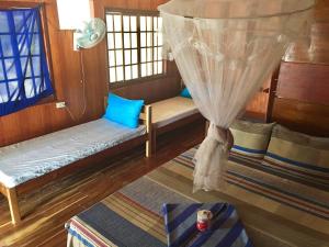 um quarto com dois bancos e uma janela com cortinas em Modessa Island em Roxas
