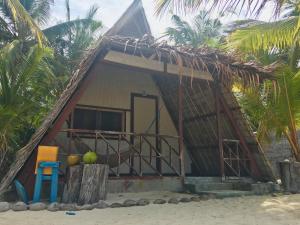 una pequeña casa en la playa con techo de paja en Modessa Island, en Roxas