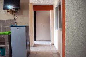 a hallway of a kitchen with a refrigerator in it at Isabel Suites in Zihuatanejo