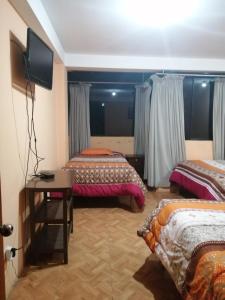 Habitación de hotel con 2 camas y mesa en Sami House, en Cusco