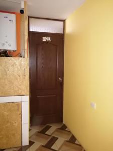 Una puerta marrón en una cocina con suelo de baldosa en Sami House, en Cusco