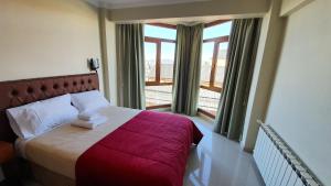 1 dormitorio con cama y ventana grande en Hotel Vitalia en Ushuaia