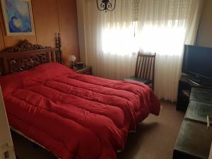 1 dormitorio con cama roja y ventana en Sur Vi Semipiso en Miramar