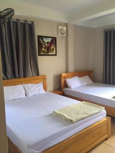 2 łóżka w małym pokoju z zapaleniem stawów w obiekcie Khách sạn Hong Kong w mieście Hòn Một