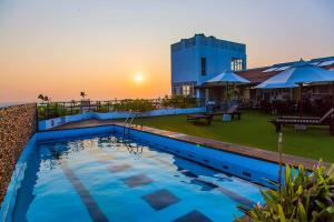 a large swimming pool in front of a building at Refresh Hotel Hikkaduwa in Hikkaduwa