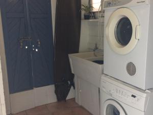 a laundry room with a washer and a washing machine at Ahoy Cottage by Discover Stradbroke in Point Lookout