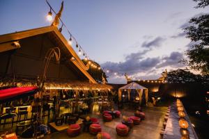 a patio with tables and chairs and lights at Hotel Tugu Malang - CHSE Certified in Malang