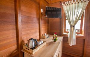 cocina con paredes de madera y mesa con TV en Villa Waturenggong Ubud, en Ubud