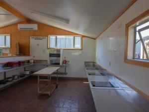 
a kitchen with a stove a sink and a window at Alpine-Pacific Holiday Park in Kaikoura
