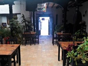 a restaurant with wooden tables and chairs and a doorway at Hosteria Del Virrey - B&B in San Cristóbal de Las Casas