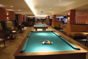 una mesa de billar en una habitación de hotel con piscina en Hotel Predium, en Vráble