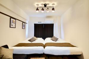 two beds in a room with a window at Allstay GOYA in Okinawa City