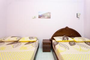 two beds sitting next to each other in a bedroom at Homestay Chin Ipoh in Ipoh