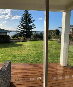 a screened in porch with a view of a yard at Tauranga Harbour Views in Tauranga