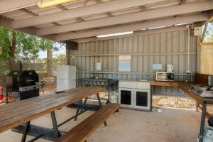 an outdoor kitchen with wooden tables in a building at Discovery Parks - Cloncurry in Cloncurry +7 photos