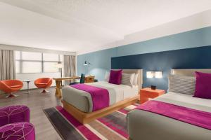 a hotel room with two beds and a couch at TRYP by Wyndham Isla Verde in San Juan