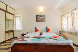 een slaapkamer met een groot bed in een kamer bij FabExpress Wenlock Homes in Ooty