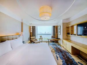 a hotel room with a large bed and a television at Pullman Linyi Lushang in Linyi