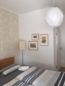 ein Schlafzimmer mit einem Bett mit einer Lampe und Bildern an der Wand in der Unterkunft FeWo Trier in Trier