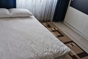 una camera da letto con un letto con una coperta bianca e uno schermo di Luxury apartment with two bedrooms and large living room, 100 square meters, city center a Oradea