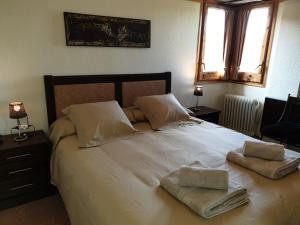 a bedroom with a large white bed with two towels on it at VUT Olimpia in Jaca