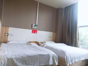 a bedroom with two beds and a window at Honey Bee Hub in Lhasa