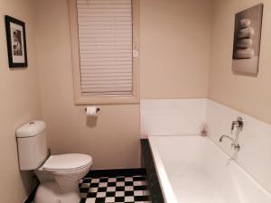 une salle de bain avec toilettes et baignoire dans l'établissement Lotte's Cottage, à Broken Hill