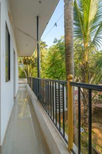 uma varanda com um corrimão preto e uma palmeira em Casa Nobert em Morjim