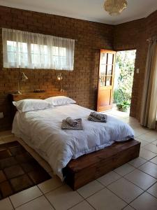 een slaapkamer met een groot bed en een bakstenen muur bij 800@Merton in Pretoria