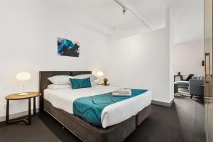 a hotel room with a bed and a desk at Docklands Private Collection - Digital Harbour in Melbourne