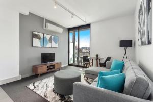 a living room with a couch and a tv at Docklands Private Collection - Digital Harbour in Melbourne